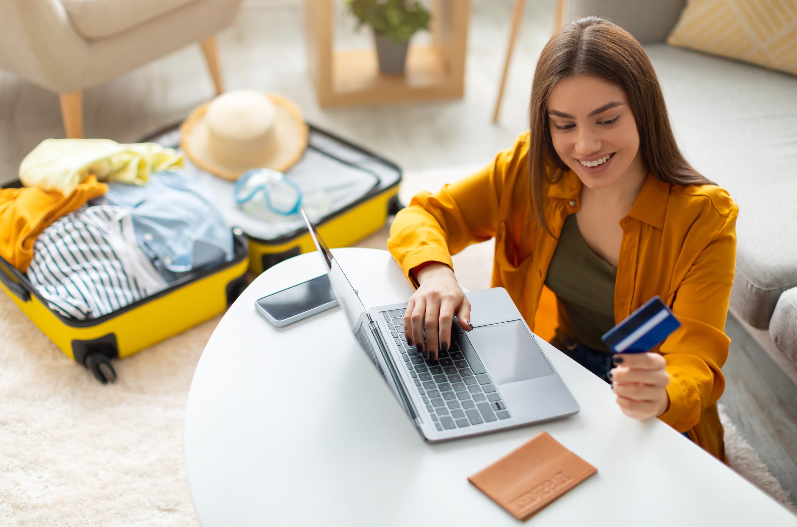 Happy,Young,Woman,With,Credit,Card,Booking,Vacation,At,Travel