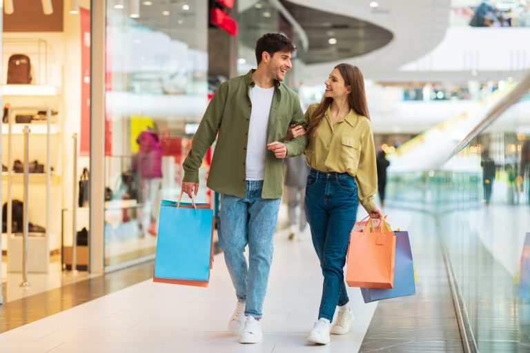 Cheerful,Couple,Shopping,Walking,Holding,Hands,Carrying,Colorful,Shopper,Bags