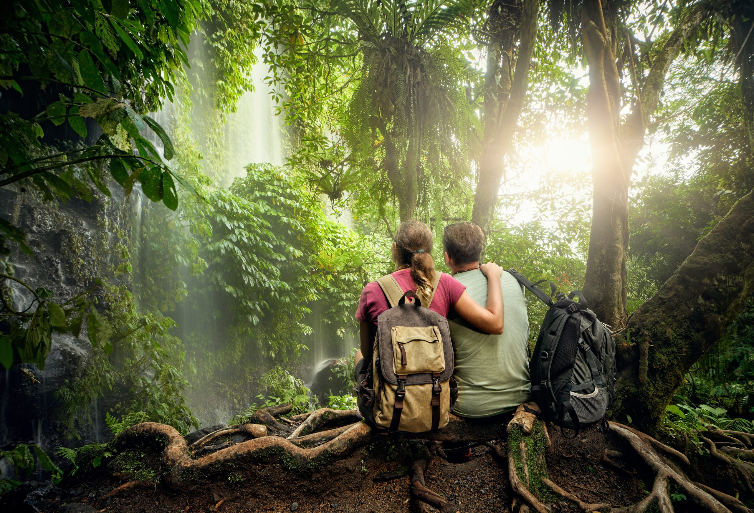 Couple,Travelers,With,Backpacks,Relaxing,In,Greens,Jungle,And,Enjoying